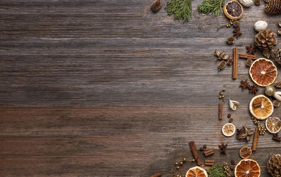 Christmas decorations on an old wooden background with cinnamon and dried orange slices. Space for text