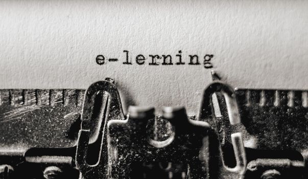 Printed text E-lerning on retro typewriter. Vintage typography font on white paper