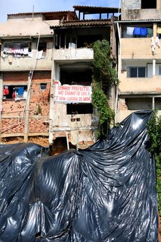 salvador, bahia, brazil - july 24, 2017: Landslide protection canvas is seen next to houses on a slope of a favela in the city of Salvador.