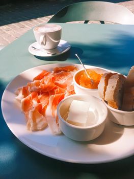 Breakfast outdoors in summer, ham, jam, butter and ham.