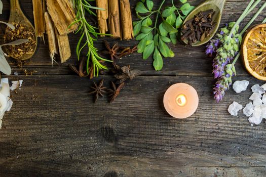 variety of flowers, herbs, candles and essences for aromatherapy, on rustic wood