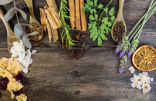 variety of flowers, herbs, candles and essences for aromatherapy, on rustic wood