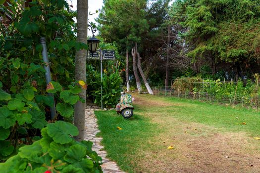 An old abandoned painted motorcycle in a garden at Corfu island, Greece.