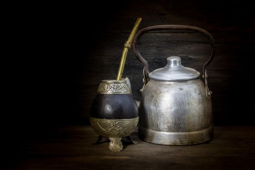 mate and kettle to drink yerba mate on rustic wood. Argentine tradition