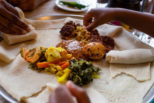 Sharing a vegetarian injera meal, with shiro, lentils, egg and a variety of vegetables