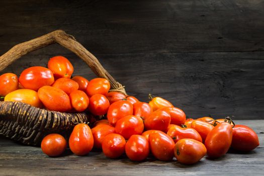 basket overflowing with pear tomatoes on rustic wood