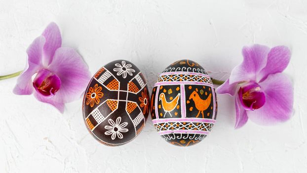 Handmade Easter eggs. Ukrainian pysanka decorated with wax-resist dyeing technique with flowers on white background