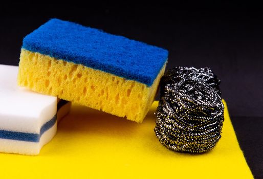 Dishwashing concept. On a black background, different washcloths and scrubbers for washing dishes.