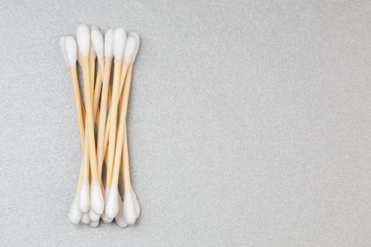 Bamboo cotton ear swabs on grey background with copy space. Sustainable hygienic accessory product concept.