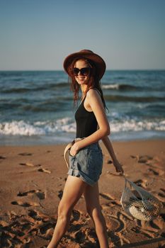 pretty woman in hat walking on the beach ocean travel. High quality photo