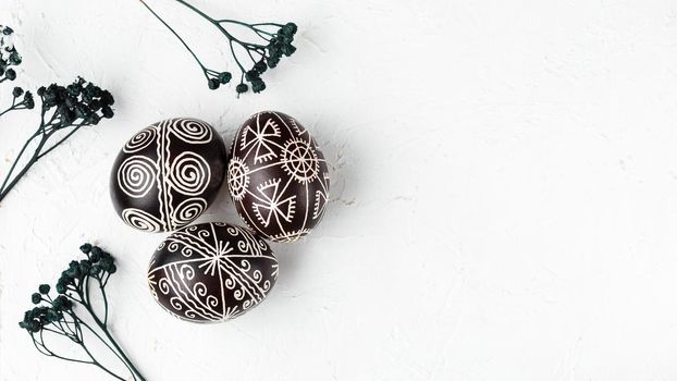 Black handmade Easter eggs. Ukrainian pysanka decorated with wax-resist dyeing technique. White background with copy empty space for text
