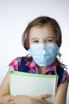 Kid school girl during pandemy going to school with a mask