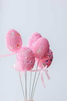 Pink easter eggs on a sticks over the white background