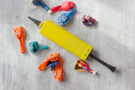 Yellow pump for blowing balloons with vivid balloons on a table