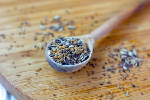 Spice mix inside the wooden spoon on a table