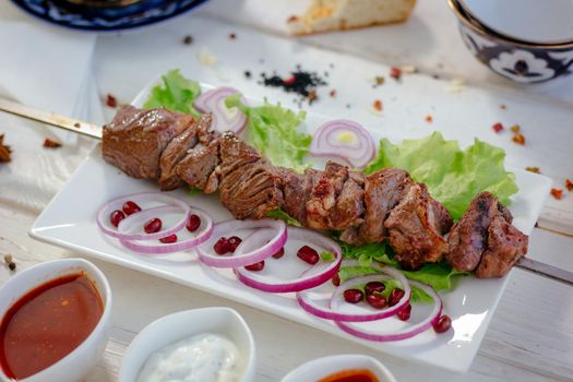 Great meat barbecue on skewer over the white plate, grilled, great image for your needs.