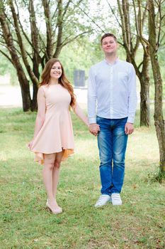 Happy young couple hold hands at park