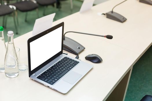 Laptop notebook hp on a white desk in a meeting room. Close up, white background