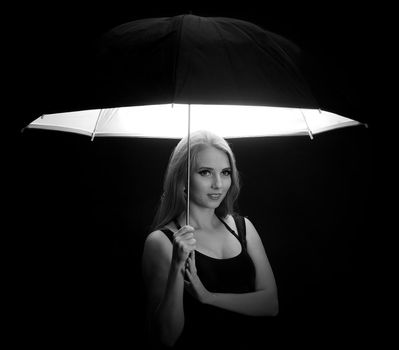 beautiful girl with black umbrella on black background