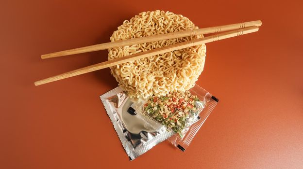 Raw instant noodles with chopsticks and spices. Copy space asian food. pasta, for the preparation of which it is enough to pour boiling water and wait a few minutes. flavored spaghetti