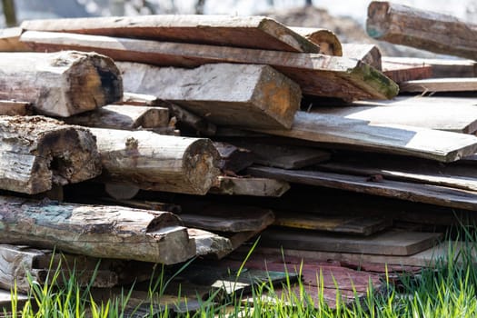 A stack of old wooden planks that lie on the ground