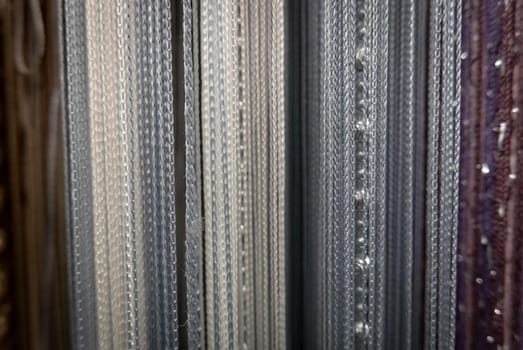 Textile strings and ropes hangs in a fabric shop. Abstract background