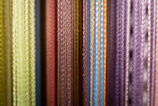 Textile strings and ropes hangs in a fabric shop. Abstract background