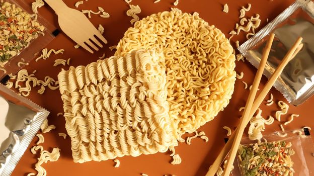 Raw instant noodles with chopsticks and spices. Copy space asian food. pasta, for the preparation of which it is enough to pour boiling water and wait a few minutes. flavored spaghetti
