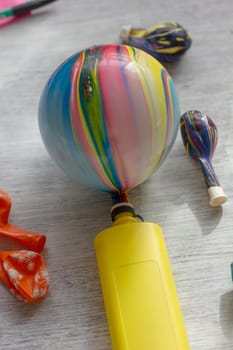 Yellow pump blowing up a balloon over the table