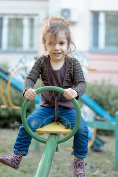 Child kid girl swinging over a playground swing