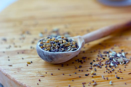 Spice mix inside the wooden spoon on a table
