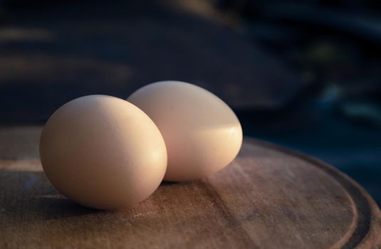 Two egg lay on the wooden table, Soft focus. Close-up two egg lay on the wooden table.