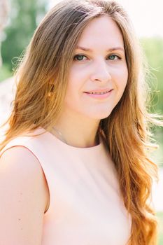 Face of young beautiful woman smiling at a park