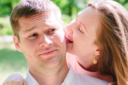 Young couple - girl bites guy to an ear