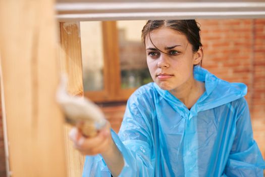 cheerful woman house painter repairing wooden structure. High quality photo