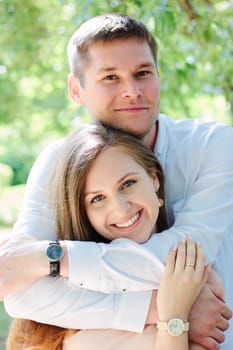 Young couple - girl and guy hugging at the park