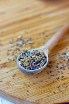 Spice mix inside the wooden spoon on a table