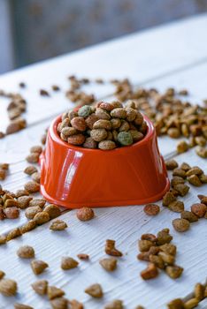 Fresh and natural dry pet food in a orange plastic bowl.