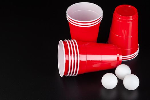 Red plastic cups and ball for game of beer pong. Close up.