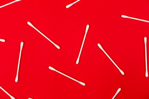 Flat lay composition with cotton swabs on red background. Top view ear sticks.