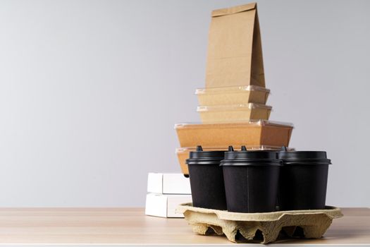 Many various take-out food containers, pizza box, coffee cups and paper bags on light grey background. Food delivery