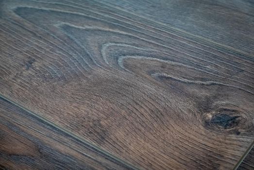 Dark brown wooden parquet floor texture as background.