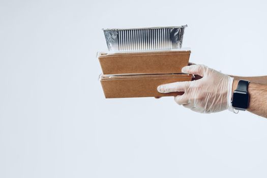 Courier hands in latex gloves giving packed food delivery close up