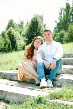 Young loving couple sitting on a stairs in a nature park