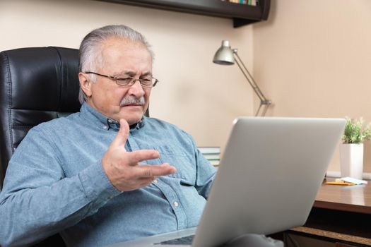 Senior man online communication. Old man makes videocall talking with relatives or friends by video conference app