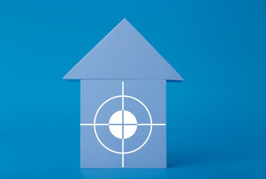 Mortgage, loan or saving money for home and investing in real estate trendy concept. Blue toy house with white target in the middle against blue background with copy space