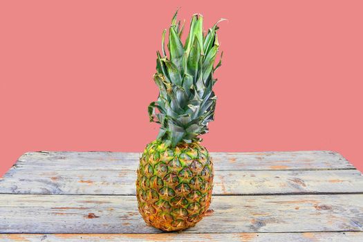 Fresh pineapple isolated against a pink background Pineapple on white wooden backgroud. Copy space.