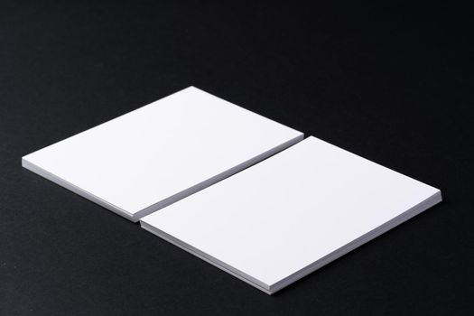 White blank business cards on dark black background, copy space