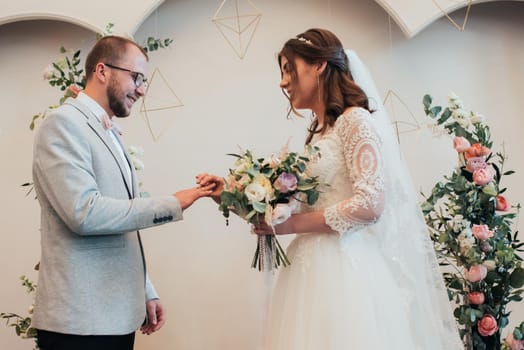 Bride and groom exchange wedding gold rings.