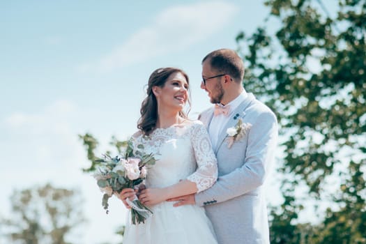 Wedding photo of the bride and groom in a gray-pink color on nature in the forest and rocks